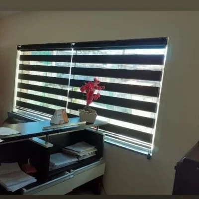 Persiana Double Vision preta instalada em ambiente comercial com mesa de escritório.